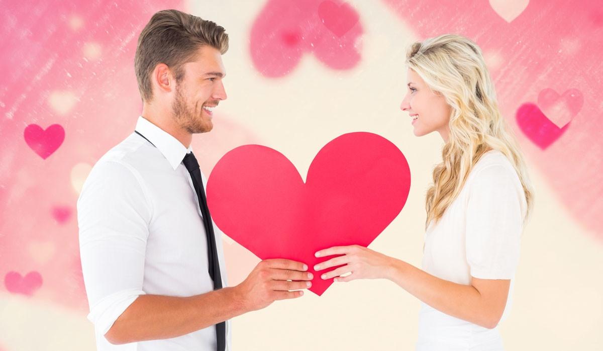 valentinsgrusspaare-die-herz-und-liebesherzhintergrund-halten